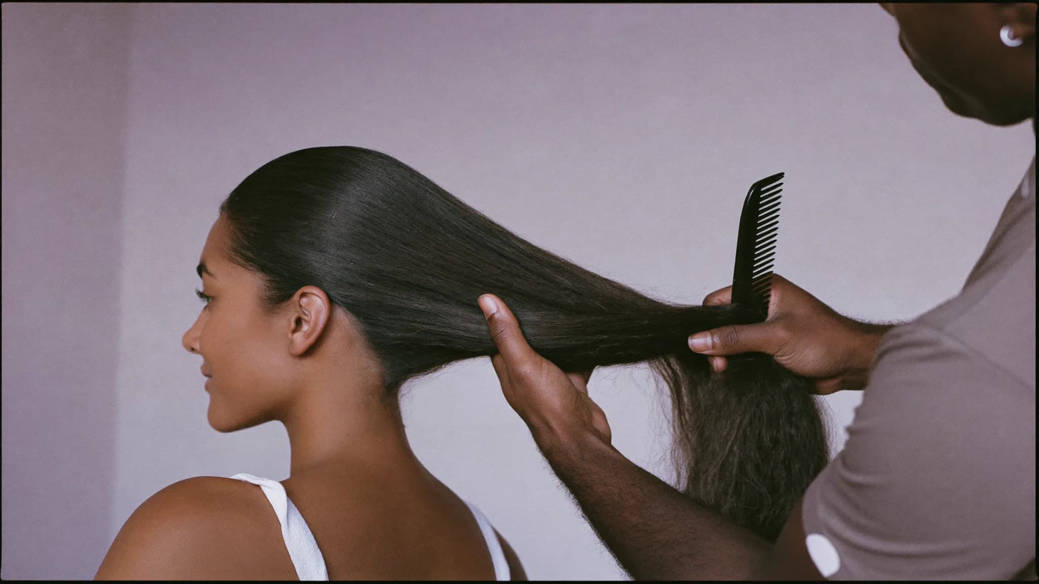 Estilista peinando el cabello largo de una clienta en Allure